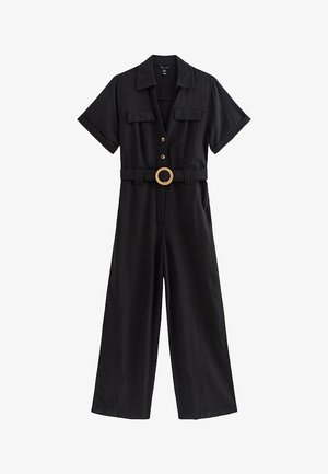 Czarny kombinezon z krótkim rękawem, szerokimi nogawkami, kołnierzem, guzikami z przodu, dwoma kieszeniami na piersi i okrągłą klamrą paska.