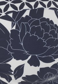 Gėlėta medžiaga, kurioje pavaizduotos didelės tamsiai mėlynos peonijos su baltu kontūru, ant balto fono su žaliais lapais.