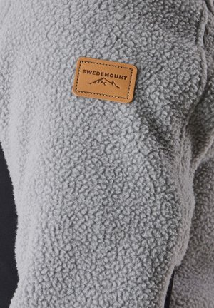 Gray fleece jacket with textured fabric, featuring a leather patch labeled "SWEDEMOUNT" attached to the upper left shoulder.