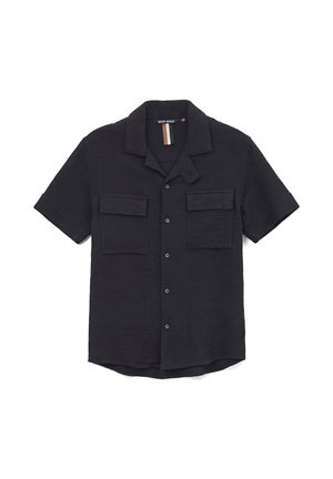 Chemise noire à manches courtes avec boutons, deux poches à rabat sur la poitrine et col cranté, posée à plat sur un fond blanc.