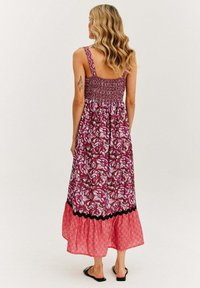 Fioletowa sukienka maxi z wzorem, z marszczonym gorsetem, ramiączkami i piętrową różową dolną częścią z misternymi wzorami.