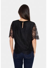 Black blouse with short lace sleeves and a keyhole back detail. The fabric features floral patterns and a smooth texture.