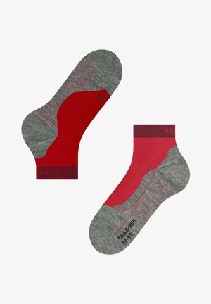 Chaussettes de sport rouges et grises avec un tissu texturé, un design en blocs de couleurs, des revers côtelés et des lignes contrastantes sur le dessus du pied.