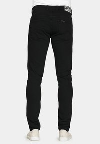 Jeans skinny neri con un classico design a cinque tasche, materiale in denim e un discreto etichetta con il marchio sulla vita posteriore.