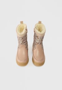 Rózsaszín gyermek téli csizmák virágmintás anyagból, szőrme béléssel, oldalsó cipzárral és gumitalppal, fehér háttér előtt.