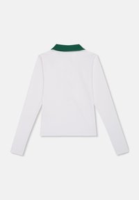 Koszulka polo z długim rękawem, biały materiał z zielonym kołnierzykiem, dopasowany krój, miękka tekstura i płaskie szwy bez zdobień.