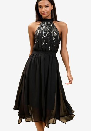 Schwarzes Halsbandkleid mit einem taillierten Oberteil aus Pailletten, geraffter Taille und einem fließenden, transparenten Rock mit seitlichen Schlitzen, der einen gestuften Look erzeugt.