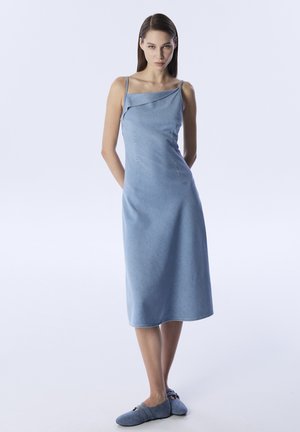 Vestido de mezclilla azul claro con un cuello asimétrico ligero, tirantes finos y una silueta simple en A, que presenta detalles de costura mínimos.