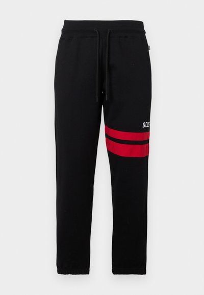 Svarta sweatpants med kontrasterande röda ränder och logotyp på sidan. Har en elastisk midja med dragsko och avsmalnande ankle cuffs.