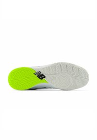 Shoe sole featuring a white base with a prominent green accent, textured tread pattern, and a black logo. Lightweight and suitable for sports.