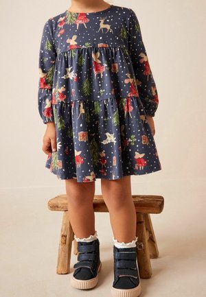 Robe bleue à manches longues avec un design à étages, arborant des motifs festifs d'animaux et d'arbres, associée à des baskets bleu marine à scratch.