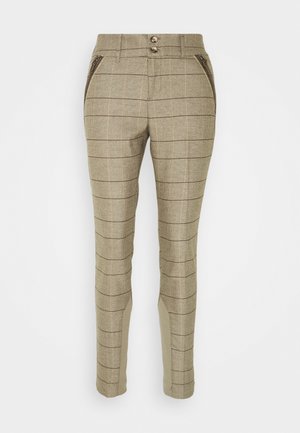 Pantalones beige de corte ajustado con fina cuadrícula negra tipo vitral, cintura con doble botón y bolsillos frontales decorativos con cremallera.