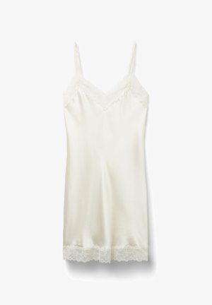 Chemise en soie couleur écru avec bretelles ajustables, dentelle le long du décolleté et de l'ourlet, texture lisse, et coupe mi-longue.