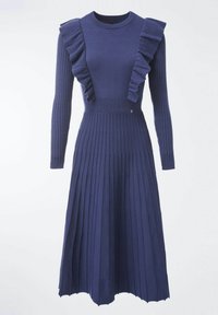 Robe en maille bleu marine avec manches longues, accents à volants sur les épaules et jupe plissée. Présente un corsage ajusté et une texture côtelée.