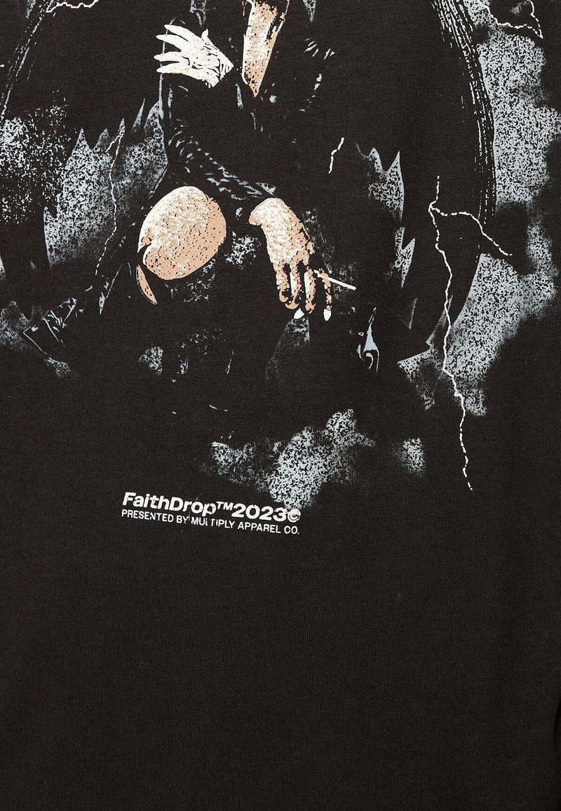 Persona con ropa oscura sentada con los brazos cruzados y una rodilla doblada, sosteniendo un cigarrillo, rodeada de patrones abstractos en negro y gris.