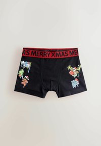 Black cotton boxer shorts with a red elastic waistband labeled "MERRY XMAS." Features festive cartoon graphics, including a Christmas tree and gingerbread man.