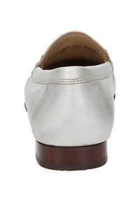 Metallisch silberner Slipper mit einer strukturierten Lederoberfläche und einem niedrigen Holzabsatz. Die Fütterung ist in einem hellen Braun und hat eine glatte Oberfläche.