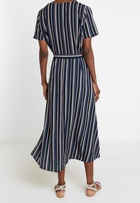 Abito a strisce blu navy con maniche corte, una cintura in vita e una gonna svasata. Il tessuto appare liscio e leggero.