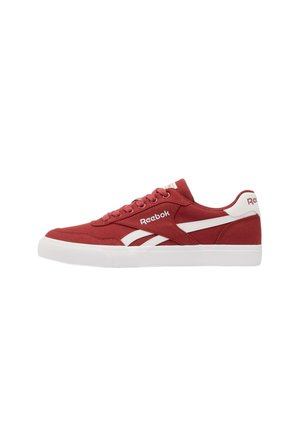 Sneaker bassa rossa Reebok con suola bianca e strisce bianche con logo sul lato, allacciatura frontale e linguetta sul tallone con marchio.