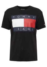 Černé bavlněné tričko s velkým obdélníkovým logem, které má bílo-červený blok na tmavě modrém pozadí, s nápisem "TOMMY JEANS."