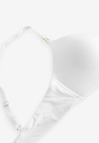 Witte bh met gladde stof, gevormde cups, verstelbare bandjes en gouden hardwareaccenten. Eenvoudig, naadloos ontwerp zonder zichtbare patronen.