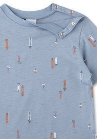 Hellblaues Kurzarm-Babykleid mit verstreutem Muster aus Türmen und Pfeilen in Braun, Weiß und Grau. Druckknopfverschluss an der Schulter.