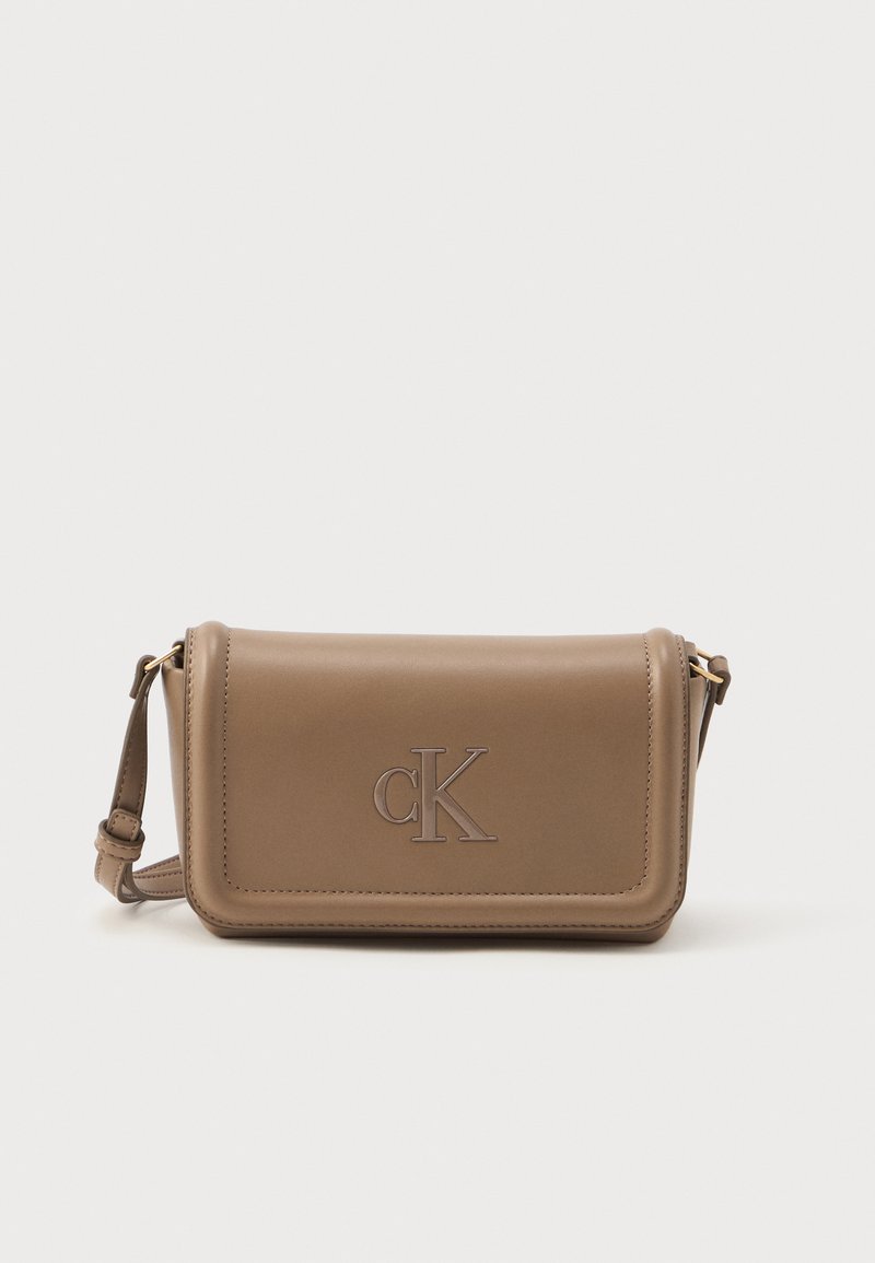 Brun skinn crossbody-veske med en glatt tekstur, med et preget "cK"-logo på forsiden og en justerbar stropp.