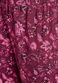 Vīna sarkanā auduma ar lielām rozā un melnām ziedu rakstiem ar sarežģītām detaļām. Mīksta tekstūra ar elastīgu vidukļa joslu.