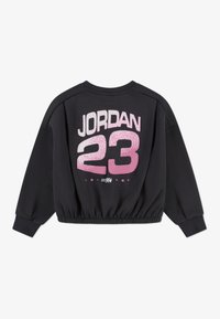Felpa nera cropped con "JORDAN" e "23" in rosa, con orlo a costine e maniche lunghe. Tessuto morbido con una consistenza liscia.