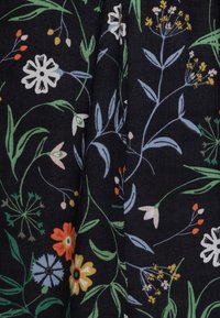 Blommönstrad tyg med vita, blå, orange och gröna blommor på en svart bakgrund; mjuk textur och lätt material.