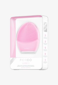 Foreo Luna 3 i rosa silikon har en rund, ergonomisk design med teksturerte børster for ansiktsrens, vist i klar emballasje.