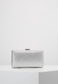 Pochette argentée de forme rectangulaire, texturée avec de petits points embossés. Dotée d'un fermoir métallique sur le dessus et de bords lisses.