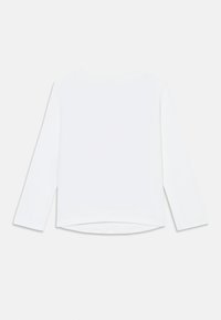 Witte langeklevende shirt met een ronde halslijn, zachte stof, zijslitsen en een lichtjes gebogen zoom aan de achterkant. Minimalistisch ontwerp.