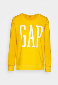 Felpa gialla in cotone, con maniche lunghe e collo rotondo. Grande logo bianco "GAP" stampato sul davanti.