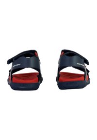 Sandalias resistentes al agua con correas en color azul marino, plantillas interiores rojas, dos cierres ajustables de Velcro y suelas exteriores de goma texturizada para un mejor agarre.