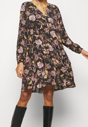 Schwarzes Blumenkleid mit langen Ärmeln, V-Ausschnitt und gerafftem Taillenteil. Der Stoff hat eine weiche, strukturierte Oberfläche mit mehrfarbigen Blumenmustern.