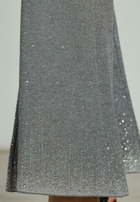 Grijze gebreide rok met een glinsterende metalen draad, versierd met kleine rhinestones, met een uitlopende vorm en een zijsplit.