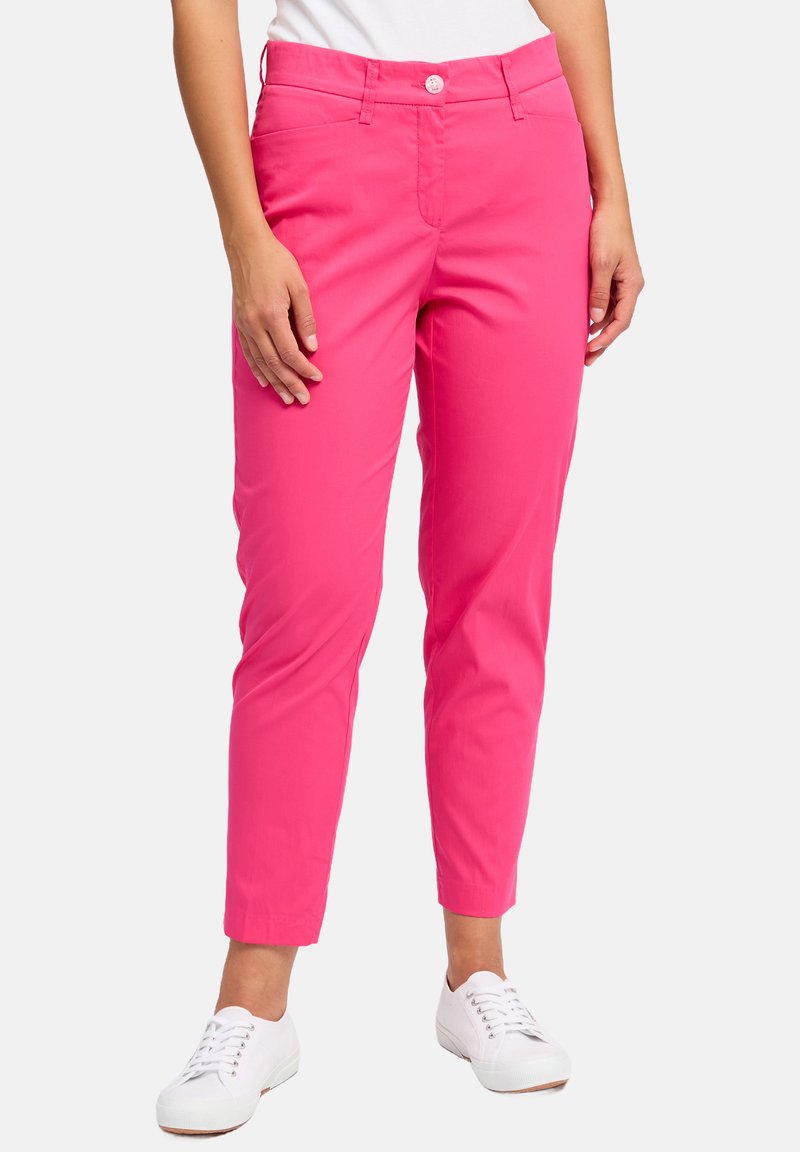 Felroze katoenen broek met een slim fit, voorzien van een knoopsluiting, zijzakken en omgeslagen boorden, gecombineerd met witte schoenen.