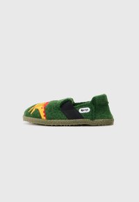 Chinela de feltro verde com uma faixa elástica preta, apresentando um design bordado em vermelho e amarelo na ponta e uma sola de borracha texturizada.