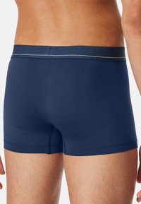 Boxer in blu navy realizzati in tessuto morbido, con una fascia in contrasto dotata di un sottile bordo, vestibilità aderente e cuciture piatte.