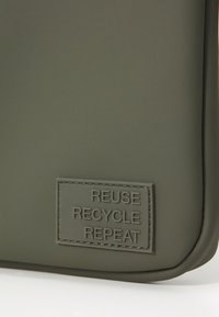 Olive green silicone pouch featuring embossed text "REUSE RECYCLE REPEAT" on a rectangular patch with a smooth finish.