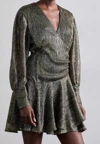 Robe en bronze métallique avec décolleté en V, manches longues froncées et jupe évasée. Le tissu texturé présente des rayures verticales.