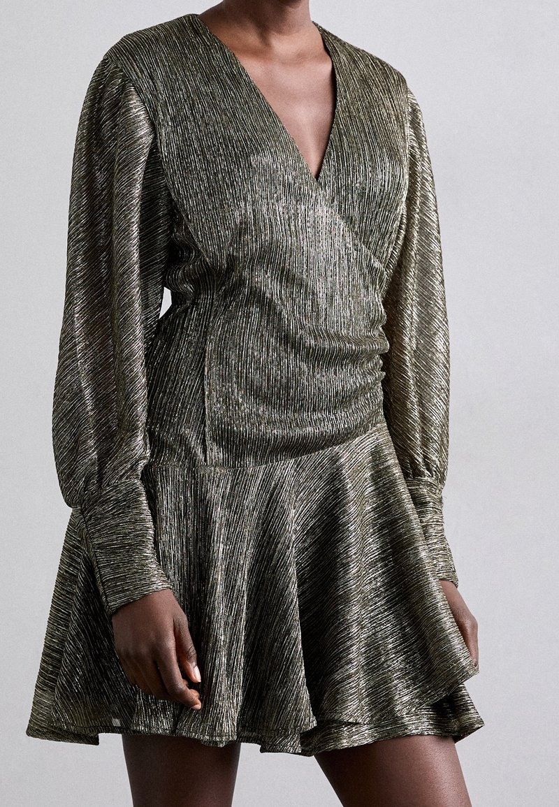 Robe en bronze métallique avec décolleté en V, manches longues froncées et jupe évasée. Le tissu texturé présente des rayures verticales.
