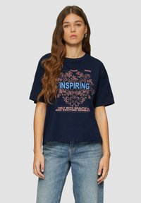 Navyblauwe katoenen t-shirt met een relaxte pasvorm, voorzien van een bloemenafbeelding en het woord "INSPIREREND" in helderblauw, vergezeld van tekstzinnen.