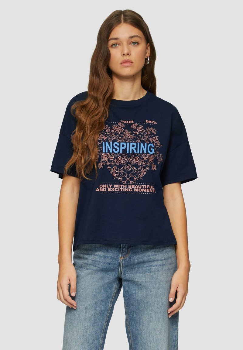 Navyblauwe katoenen t-shirt met een relaxte pasvorm, voorzien van een bloemenafbeelding en het woord "INSPIREREND" in helderblauw, vergezeld van tekstzinnen.
