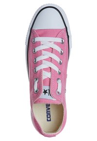 Pink canvas sneaker with white rubber toe cap, laces, and eyelets. Features a textured upper and black sole with logo detail inside.