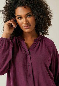 Camicia a maniche lunghe color prugna, con bottoni e colletto arricciato, realizzata in un tessuto testurizzato e con fit comodo.