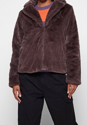 Brun faux fur jakke med hætte, lynlås lukning og lange ærmer. Blød tekstur, let cropped design, parret med sorte cargo bukser.