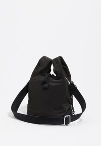 Bolsa de nylon negra con un diseño holgado, doble asa superior, correa ajustable y una superficie texturizada. Presenta acentos de hardware seguros.