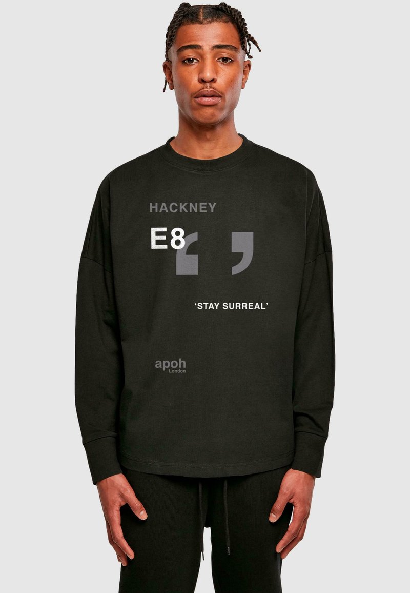 Must musta särk, millel on pikad varrukad, valmistatud puuvillast, esiküljel on graafiline tekst "HACKNEY E8" ja "STAY SURREAL". Omab mugavat lõiget ja ümmargust kaelust.